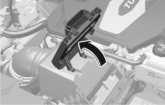 2025 Genesis GV70 air cleaner cover image. A thick black curved arrow points upward, indicating the direction to lift the black plastic air cleaner cover in the engine compartment. Explains the function of pulling up the cover to replace the air cleaner filter.