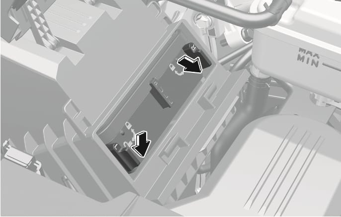 2025 Genesis GV70 air cleaner filter replacement image. Two black levers labeled L and R are shown on the housing. Large black arrows with white outlines point downwards, indicating the direction to pull the levers from the lock icon to the unlock icon. Explains the function of pulling down the levers to the unlock position to remove the air cleaner cover.