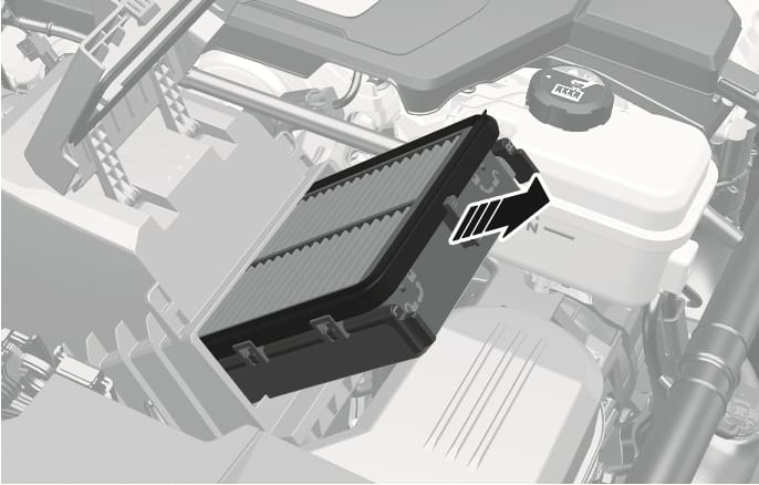 2025 Genesis GV70 air cleaner filter replacement image. The air cleaner cover is open, and the rectangular filter is being pulled out from the housing. A large black arrow with white stripes points to the right, indicating the direction of removal. Explains the process of removing the air cleaner filter.