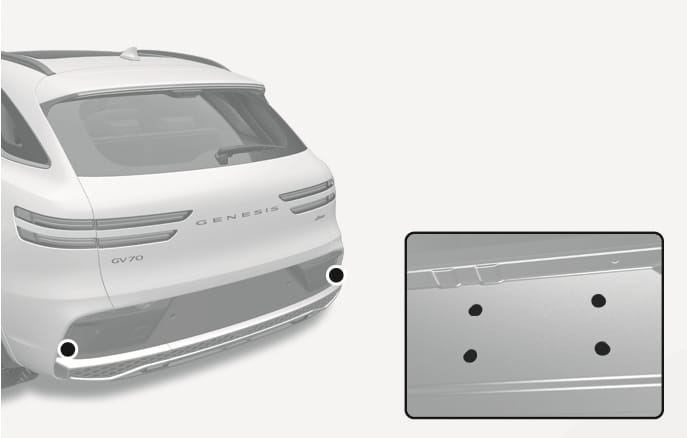 2025 Genesis GV70 trailer hitch mounting points image. The rear view highlights the lower bumper with black circular markers. An inset shows four mounting holes arranged in a rectangle on the vehicle frame. This illustrates the designated points for installing a frame-mounted trailer hitch.