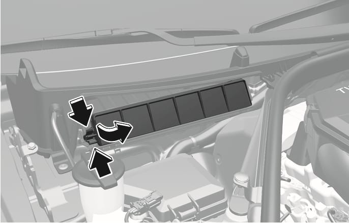 2025 제네시스 GV70 엔진룸 에어 필터 커버 분리 이미지입니다. 엔진룸 내부 와이퍼 하단에 위치한 에어 필터 커버의 왼쪽 고정 부위를 가리키는 두 개의 검은색 화살표와, 커버를 바깥쪽으로 당겨내는 방향을 지시하는 굽은 화살표가 표시되어 있습니다. 에어 필터 커버의 왼쪽을 누른 상태에서 잡아당겨 커버를 분리하는 기능을 설명합니다.