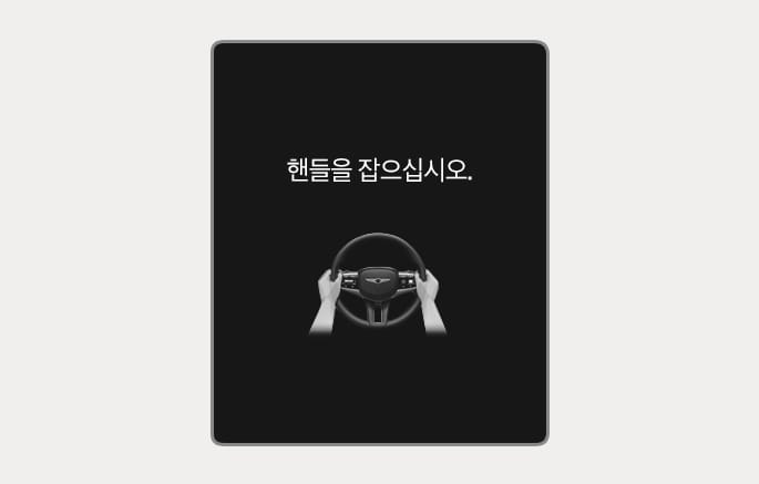 2025 제네시스 GV70 핸즈오프 경고 화면 이미지입니다. 검은색 배경의 클러스터 화면 중앙에 '핸들을 잡으십시오.'라는 문구와 스티어링 휠을 양손으로 잡고 있는 그래픽이 표시되어 있습니다. 고속도로 주행 보조 중 운전자가 핸들을 잡지 않을 경우 경고문과 함께 핸들을 잡도록 안내하는 기능을 설명합니다.