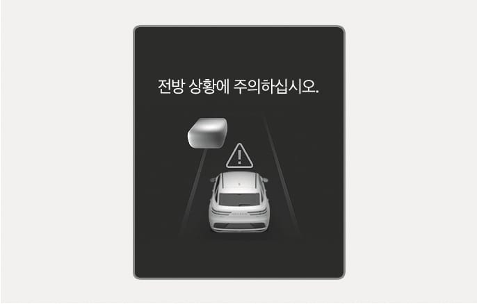 2025 제네시스 GV70 전방 상황 주의 경고 화면 이미지입니다. 어두운 배경의 클러스터 화면 중앙에 '전방 상황에 주의하십시오.'라는 문구가 있습니다. 그 아래에는 주행 차선 위 자차와 전방 물체 사이에 삼각형 모양의 느낌표 아이콘이 떠 있습니다. 스마트 크루즈 컨트롤 주행 중 전방 주시가 필요한 상황임을 운전자에게 알리는 기능을 설명합니다.